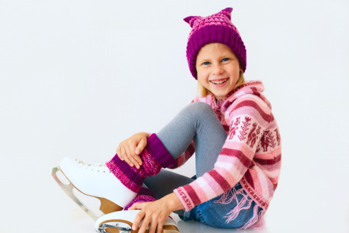 cheerful girl sitting on ice skates